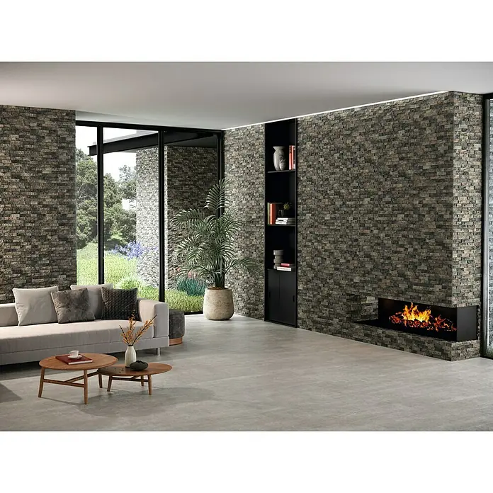 Verblendstein Irazu Mix - 60 x 20 cm, Braun, Steinoptik - Elegantes Wohnzimmer mit einer markanten Steinwand, die einen modernen Kamin und ein integriertes Regal umfasst. Stilvolles Interieur mit Naturakzenten.
