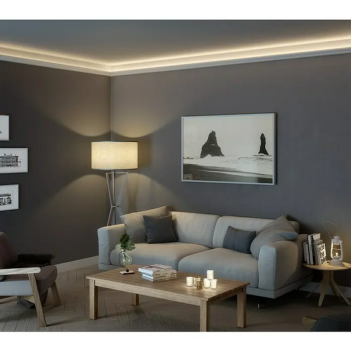 Nmc Decoflair Zierprofil CL11 - L x B x H: 2 m x 33 mm x 50 mm, Hochverdichtetes extrudiertes Polymer (HDPS) - Einrichtung eines Wohnzimmers mit grau gestrichenen Wänden, einem Sofa, einem Tisch und einer Deckenleuchte.