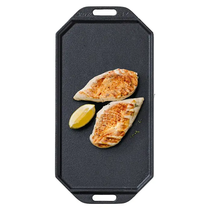 Cozze Grillpfanne - L x B: 30 x 15 cm, Höhe: 1 cm, Gusseisen - Gegrillte Hähnchenbrust mit Zitrone auf einer schwarzen Grillplatte. Das perfekte Gericht für ein schnelles und gesundes Mittagessen.