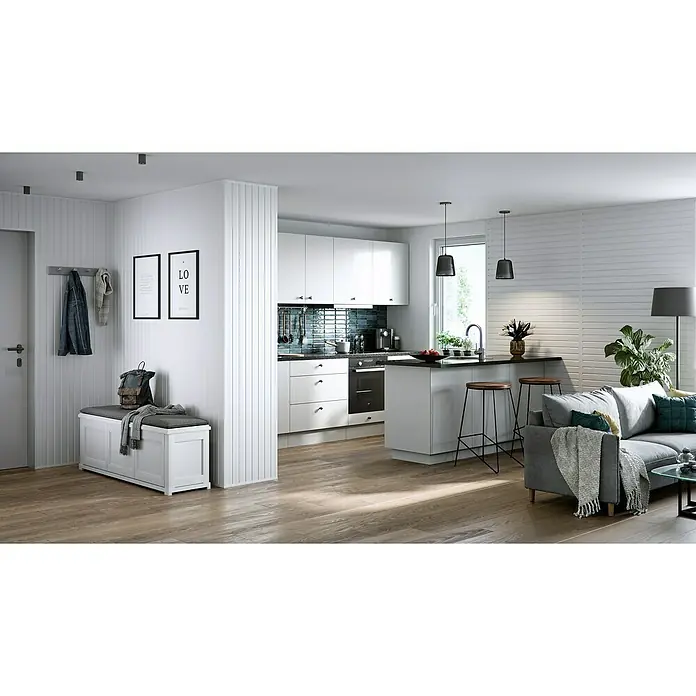 BaukulitVox Basic-Line Abschlussleiste - L x B x H: 3.000 x 20 x 10 mm, PVC - Eine stilvolle Küchen- und Wohnraumkombination mit weißen Küchenschränken, einer Kochinsel mit Hockern und einem grauen Sofa in einem hellen, offenen Design.