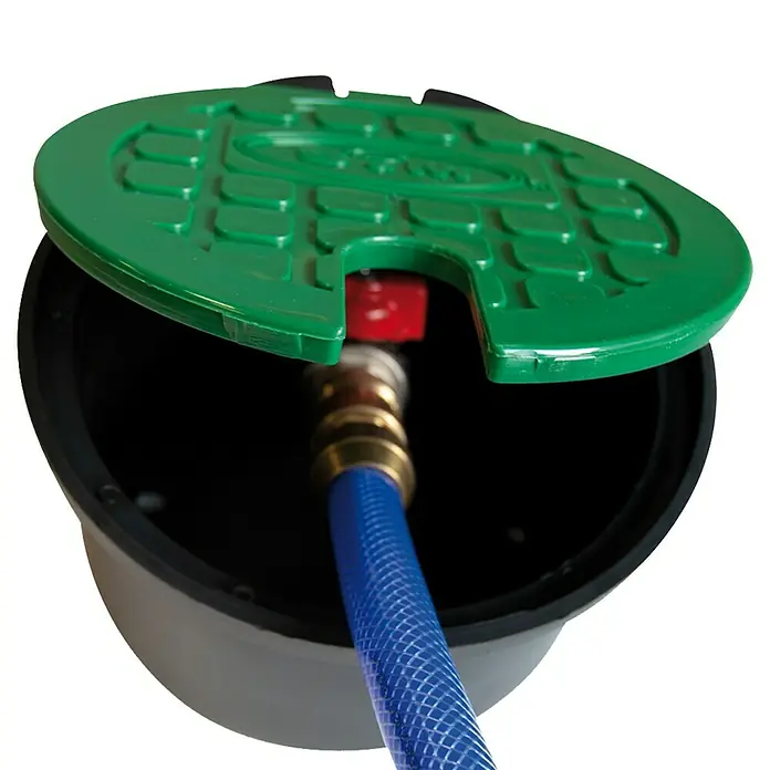 Arqueta redonda con tapa - Dimensión conexión: ¾″ - Imagen de una caja de riego con tapa verde y conexión de manguera azul, ideal para el riego del jardín.