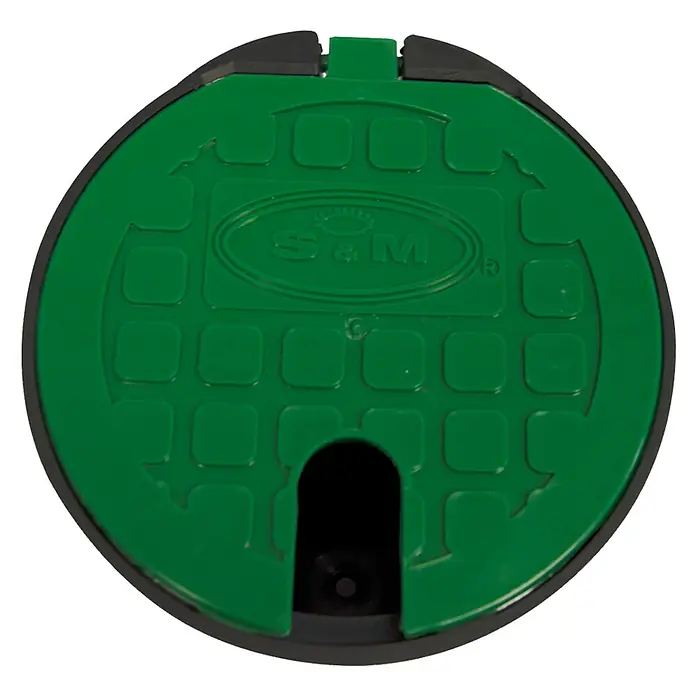 Arqueta redonda con tapa - Dimensión conexión: ¾″ - Tapa de caja de válvulas S&M de plástico verde, un accesorio para sistemas de riego de jardín, con un patrón rectangular y logotipo.