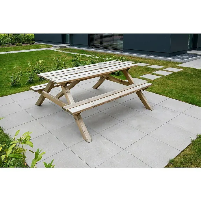 Diephaus Gehwegplatte - 50 x 50 x 4 cm, Grau, Beton - Hölzerner Picknicktisch auf einer Steinterrasse mit Rasenflächen. Die schlichte Konstruktion bietet Platz für Mahlzeiten im Freien.