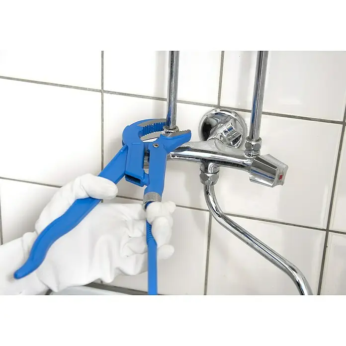 Alpha Tools Wasserpumpenzange - 3 -tlg., Stahl - Nahaufnahme einer Person mit weißen Handschuhen, die mit einer blauen Rohrzange an einem Wasserhahn arbeitet, gefliestem Hintergrund.