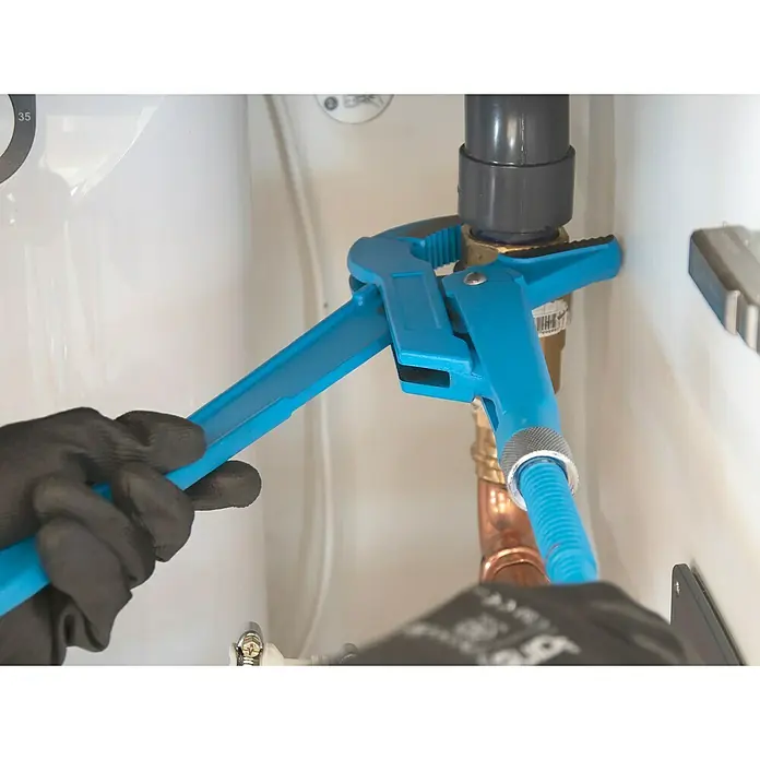 Alpha Tools Wasserpumpenzange - 3 -tlg., Stahl - Blaue Rohrzange im Einsatz an einem Kupferrohr, gehalten von Händen mit schwarzen Handschuhen, für Sanitär- oder Reparaturarbeiten.