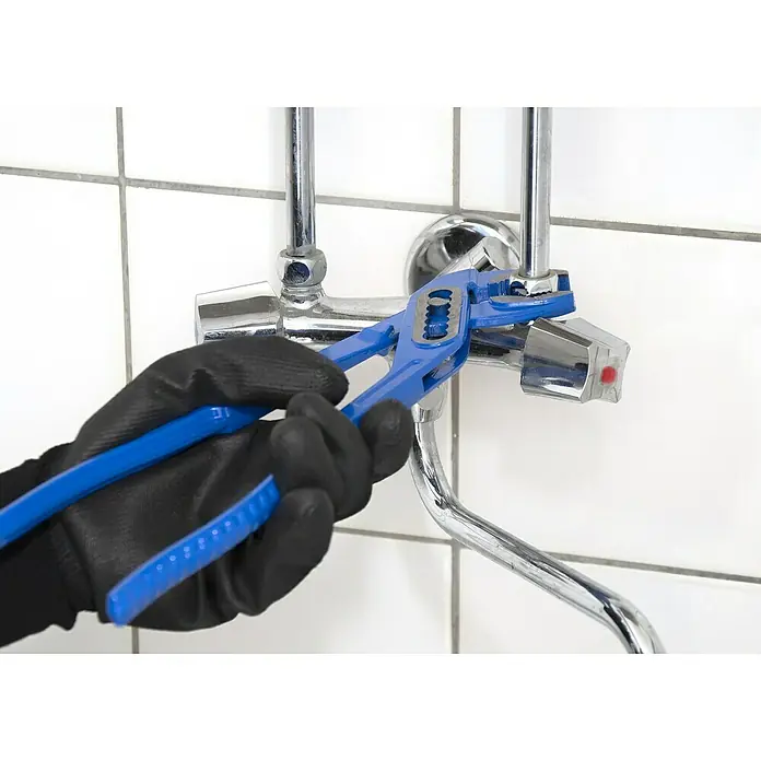 Alpha Tools Wasserpumpenzange - 3 -tlg. - Nahaufnahme einer Person mit schwarzen Handschuhen, die mit einer blauen Rohrzange an einem verchromten Wasserhahn arbeitet.