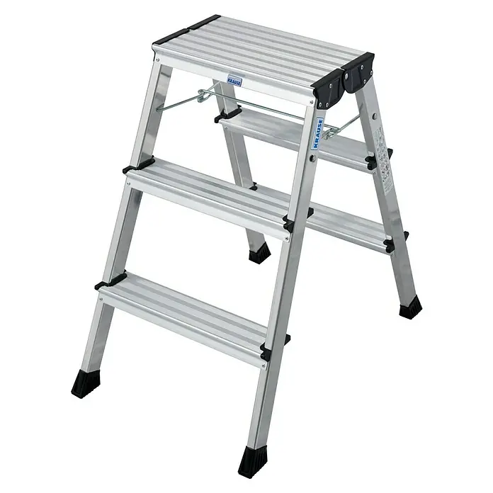 Krause Monto Klapptritt Rolly Alu - Anzahl Tritte: 6 Stk., Arbeitshöhe: 2,65 m, Belastbarkeit: 150 kg, Aluminium - Eine dreistufige, silberne Krause-Leiter mit schwarzem Zubehör, ideal für verschiedene Aufgaben im Haus oder in der Werkstatt.