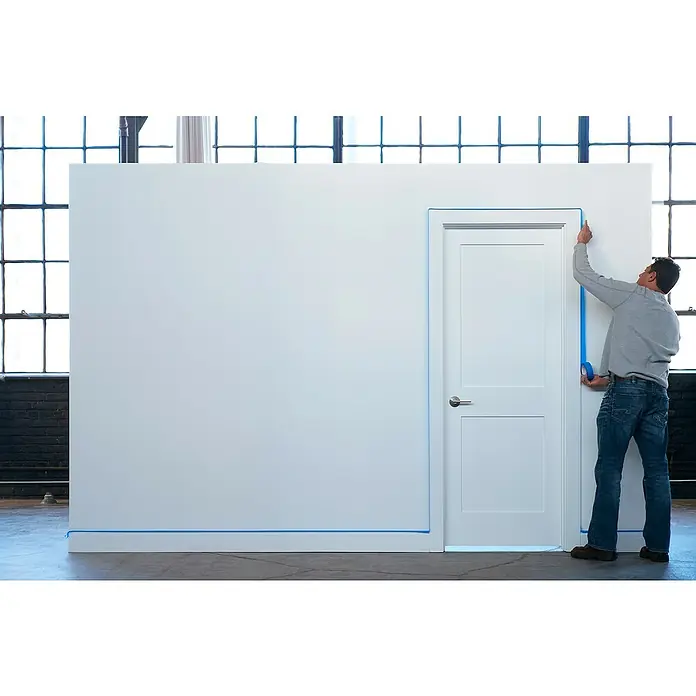 3M Cinta de enmascarar ScotchBlue - Azul, An x L: 24 mm x 41 m, 1 ud. - Un hombre aplica cinta de pintor a una puerta y pared, protegiéndolas antes de pintar. La cinta azul asegura líneas limpias.