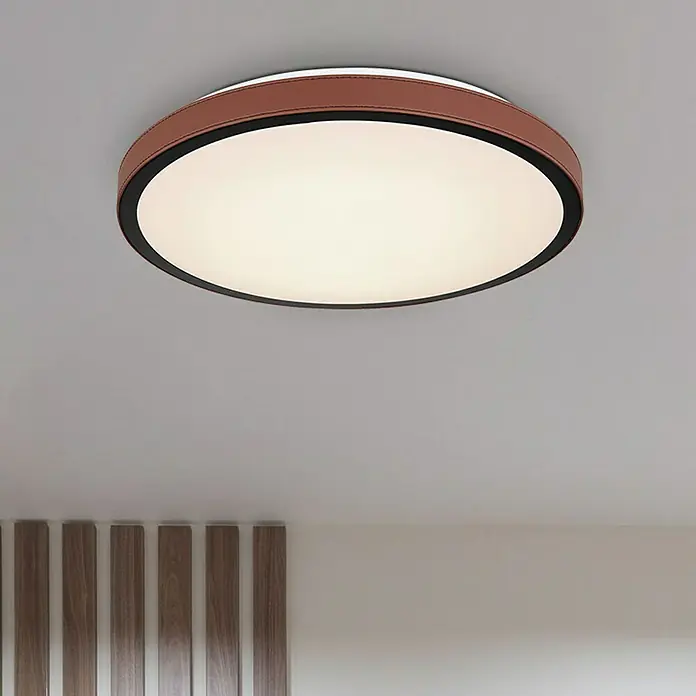 Globo LED-Deckenleuchte rund SAMMI - 24 W, Ø x H: 420 mm x 9,5 cm, Dunkelbraun, Warmweiß - Nahaufnahme einer runden Deckenleuchte mit braunem Lederakzent und schwarzem Rand, die ein warmes, diffuses Licht in den Raum wirft.