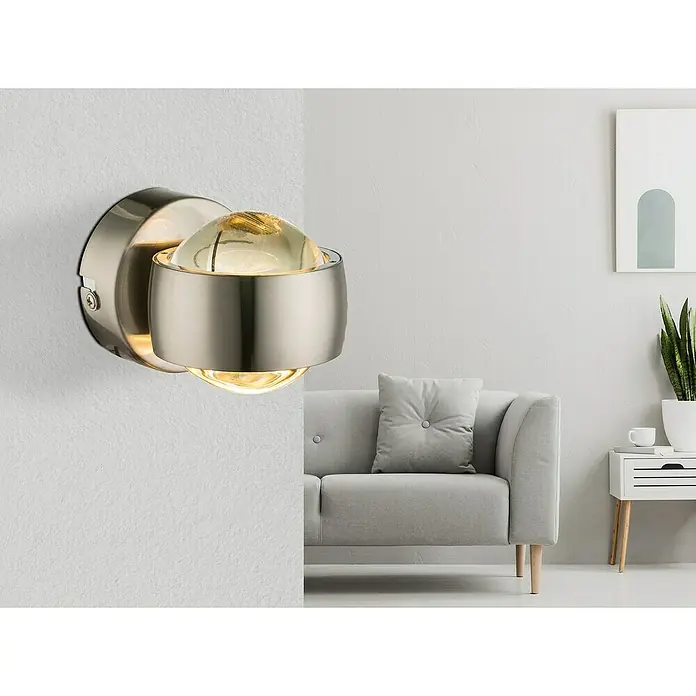 Globo Wandleuchte RANDI - 6 W, Nickel-matt, Sonstige - Nahaufnahme einer modernen Wandleuchte mit einem satinierten Nickel-Finish und einer klaren Glaskugel, die warmes Licht ausstrahlt.