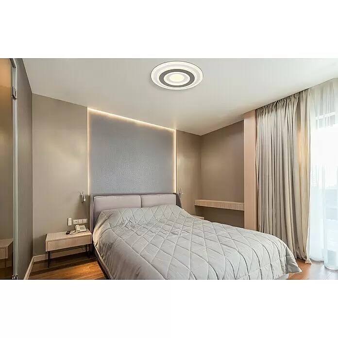 Globo LED-Deckenleuchte SABATINO rund - 36 W, L x B x H: 38 x 38 x 5,5 cm, Weiß, Warmweiß, Rund - Modernes Schlafzimmer mit großem Bett, grauer Steppdecke, Nachttischen, eingebautem Schreibtisch und hellen Vorhängen in neutralen Tönen.