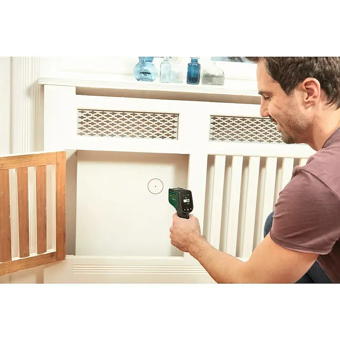 Bosch Advanced Temperaturmessgerät AdvancedTemp - Messbereich: -30 °C bis +500 °C - Ein Mann verwendet eine Bosch Wärmebildkamera, um die Temperatur einer weißen Heizkörperabdeckung zu messen. Das Gerät zeigt 35,1 Grad an.