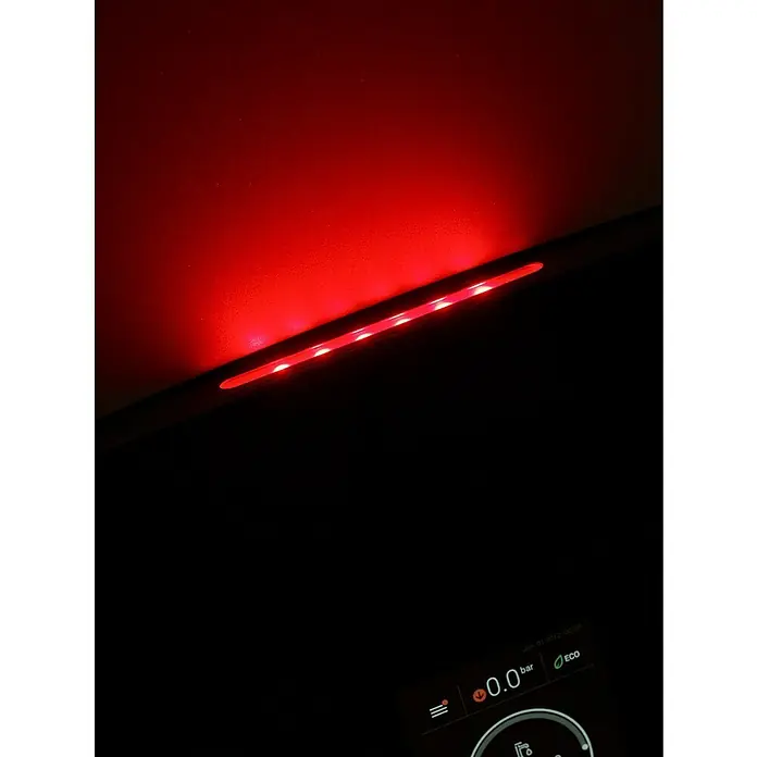 Ferroli Caldera BlueHelix Maxima 28C con instalación incluida - Display multifunción, Capacidad volumétrica: 8 l, 24,5 kW - Un primer plano de la iluminación interior que proyecta un brillo rojo futurista sobre una superficie oscura.
