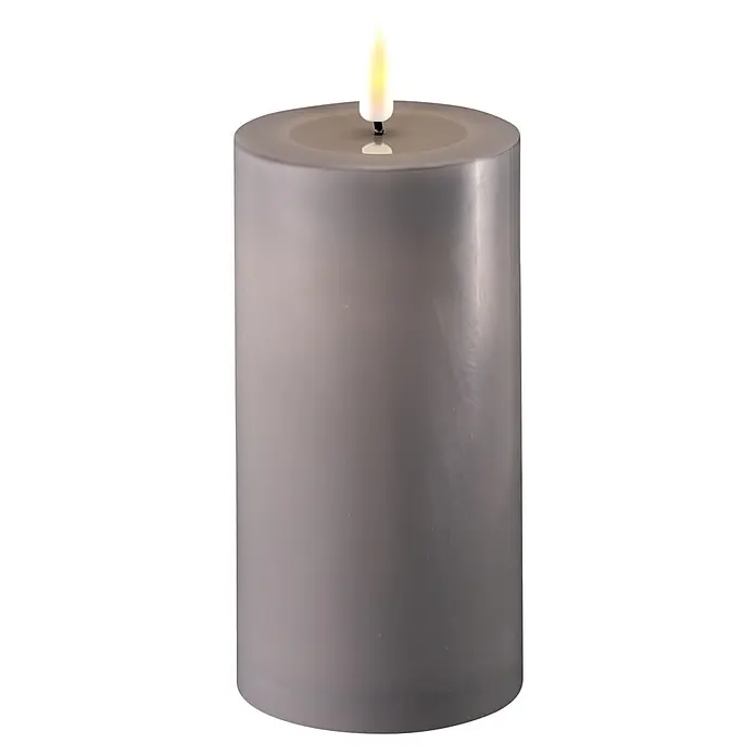 DeluxeHomeart LED-Kerze Indoor - Grau, Ø x H: 7,5 x 15 cm, Echtwachs - Nahaufnahme einer dekorativen grauen Stumpenkerze mit realistischer LED-Flamme, die ein warmes und beruhigendes Licht erzeugt.