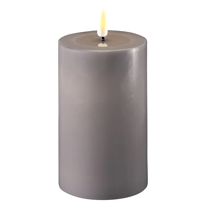 DeluxeHomeart LED-Kerze Indoor - Grau, Ø x H: 7,5 x 12,5 cm, Echtwachs - Nahaufnahme einer dekorativen grauen Stumpenkerze mit LED-Flamme, die eine gemütliche und sichere Atmosphäre schafft.