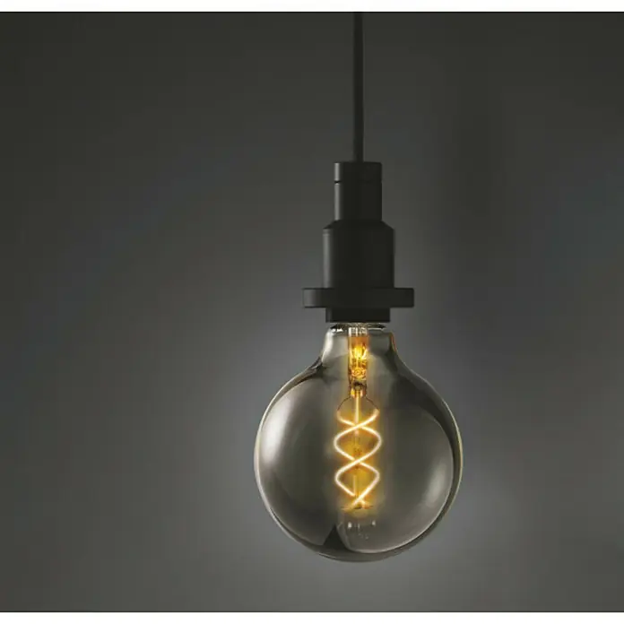 Osram Vintage 1906 Bombilla LED - E27, Blanco cálido, 150 lm, 5 W - Primer plano de una bombilla Edison con un filamento en espiral que emite una luz cálida, suspendida de un cable negro.