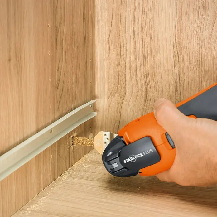 Fein Starlock Plus Hartmetall-Feile - 30 x 10 mm - Das Bild zeigt ein oszillierendes Multifunktionswerkzeug beim Sägen eines Holzes mit dem "Starlock Plus"-System, das präzise Schnitte ermöglicht.