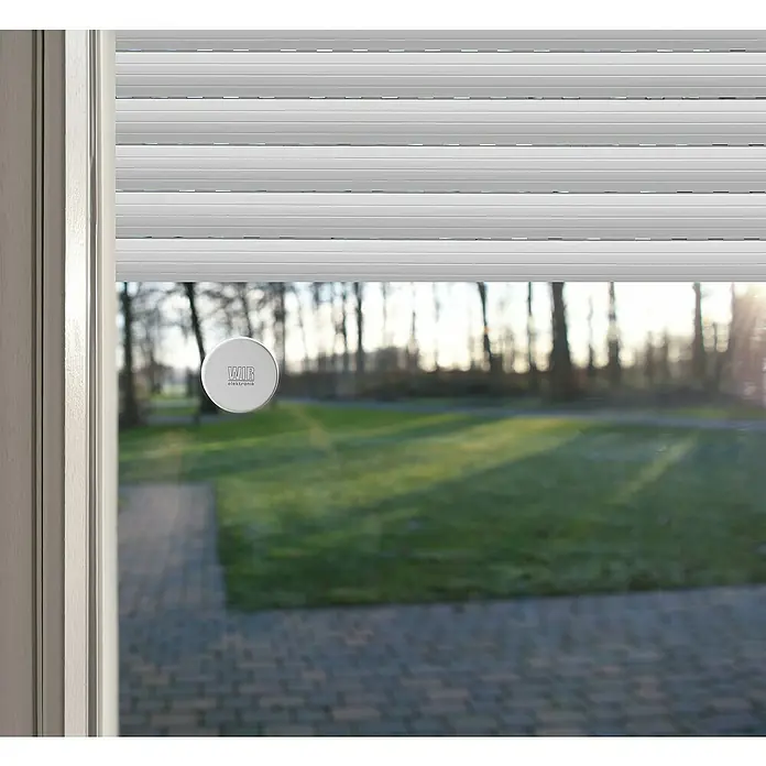 WIR elektronik Sonnensensor Funk eSO400 - Weiß - Detailansicht eines Fensters mit Rollladen und einem runden WIR elektronik Aufkleber auf der Scheibe, der das Firmenlogo zeigt.