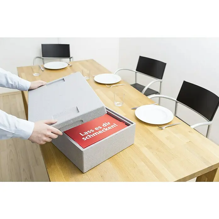 BAUHAUS Caja Euro - 60 l, L x An x Al: 60 x 40 x 32 cm, Gris, Abierta - Un recipiente gris con un letrero rojo "Lass es dir schmecken!" se encuentra en una mesa puesta.