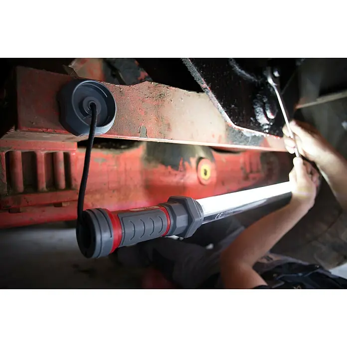 Profi Depot LED-Arbeitsleuchte XXL - Länge: 1 m - Eine Akku-Arbeitsleuchte mit Magnetfuß leuchtet eine Reparatur unter einem Fahrzeug aus. Ideal für präzise Arbeiten.