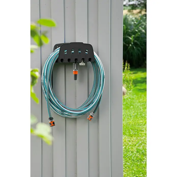 Gardena Classic Wand-Schlauchhalterung Set - Länge: 20 m, Schlauchdurchmesser: 13 mm - Gardena Schlauchhalter mit aufgerolltem Gartenschlauch an einer grauen Wand, ideal zur Gartenbewässerung und ordentlichen Aufbewahrung.