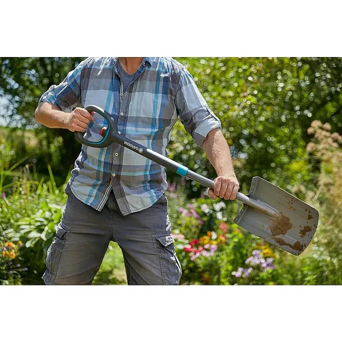 Gardena Ergoline Gärtnerspaten - Ergonomischer Stiel, Länge Stiel: 106 cm - 126 cm - Mann hält einen Gardena Spaten im Garten. Der Spaten ist grau und hat einen Griff mit orangefarbenen Akzenten.