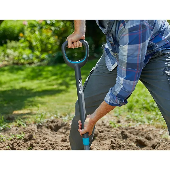 Gardena Ergoline Spatengabel - Anzahl Zinken: 4, Ergonomischer Stiel - Nahaufnahme einer Person, die einen GARDENA Spaten im Garten benutzt.