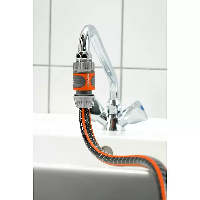Gardena Schlauchanschluss-Set - 3 -tlg. - Gardena Schlauchanschluss und schwarz-oranger Schlauch an verchromtem Küchenhahn.