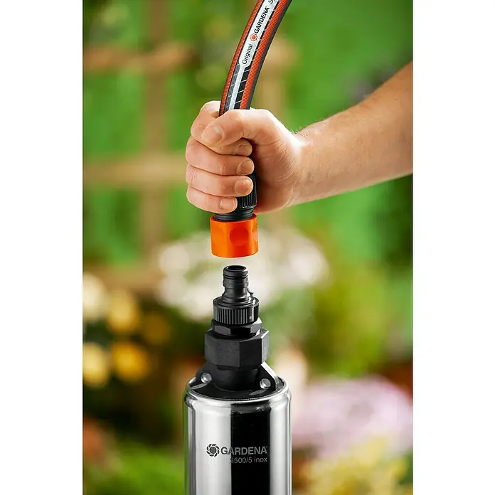 Gardena Tiefbrunnenpumpe 5500/5 Inox - 850 W, 5.500 l/h, Edelstahl - Eine Hand schließt einen Gardena-Gartenschlauch an eine Gardena 6500/5 inox-Gartenpumpe an.