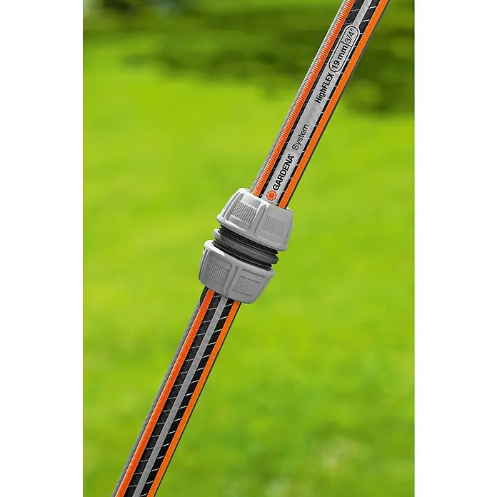 Gardena Reparator - 2 Stk. - Nahaufnahme eines Gardena HighFLEX-Gartenschlauchs mit Verbinder vor einem grünen Rasen.