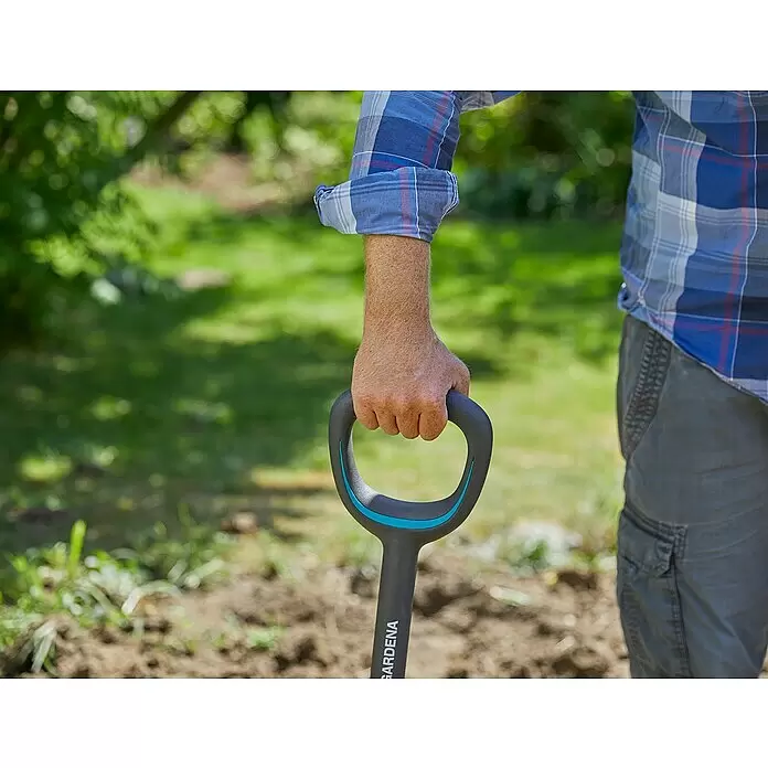 Gardena Ergoline Spatengabel - Anzahl Zinken: 4, Ergonomischer Stiel - Hand hält einen dunkelgrauen und blauen GARDENA Spatengriff im Garten.