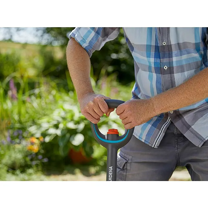 Gardena Ergoline Gärtnerspaten - Ergonomischer Stiel, Länge Stiel: 106 cm - 126 cm - Nahaufnahme einer Person, die einen Gardena Spaten mit Griffen in einem Garten hält.