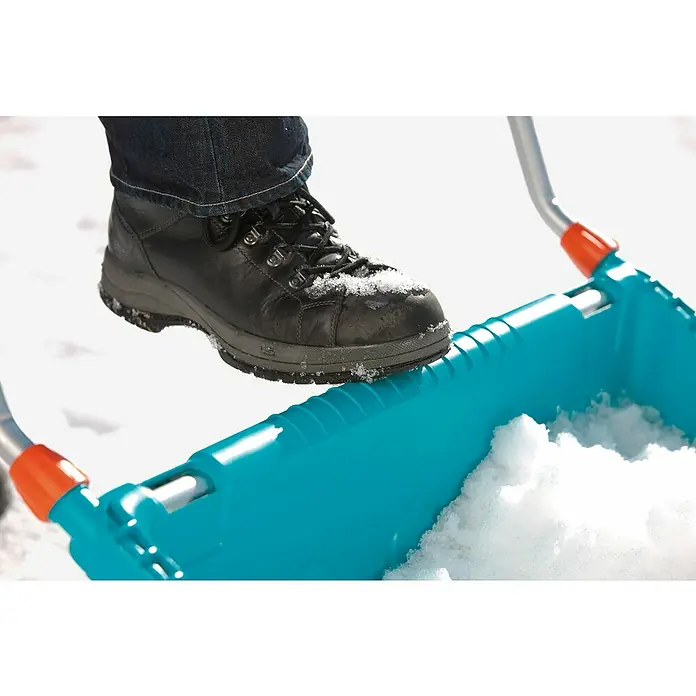 Gardena Schneewanne - Breite: 70 cm, Teleskopstiel, Kunststoff - Nahaufnahme einer blauen Schneeschaufel mit Fuß darauf, ideal zum einfachen Schneeräumen.