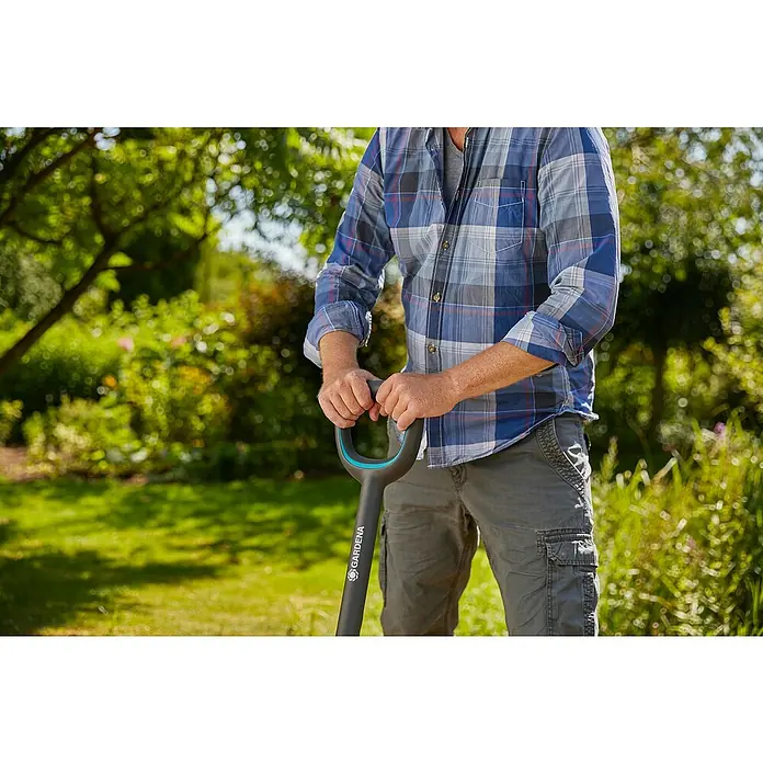 Gardena Ergoline GärtnerspatenMit Tritt, 117 cm - Ein Mann im Garten hält einen Gardena Spaten mit grauem Griff. Ideal für Gartenarbeit und zum Umgraben von Erde, präsentiert mit Fokus auf Ergonomie.