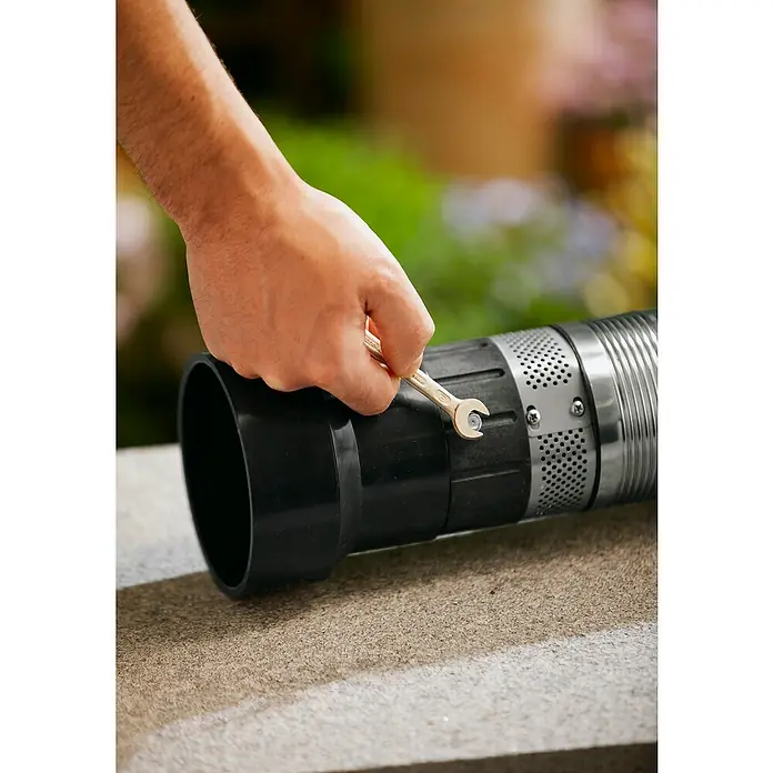 Gardena Tiefbrunnenpumpe 5500/5 Inox - 850 W, 5.500 l/h, Edelstahl - Eine Hand zieht eine Schraube an einem Rohr fest. Der Schraubenschlüssel wird auf der Schraube angesetzt, um die Verbindung festzuziehen.