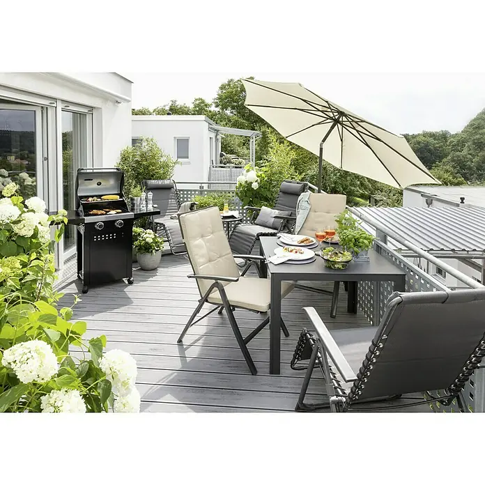 Sunfun Marktschirm rund Torino - Natur, Durchmesser Bespannung: 270 cm - Ein Esstisch mit Stühlen und Grill auf einer Terrasse, umgeben von üppigem Grün. Sonnenschirm bietet Schatten für Mahlzeiten im Freien.