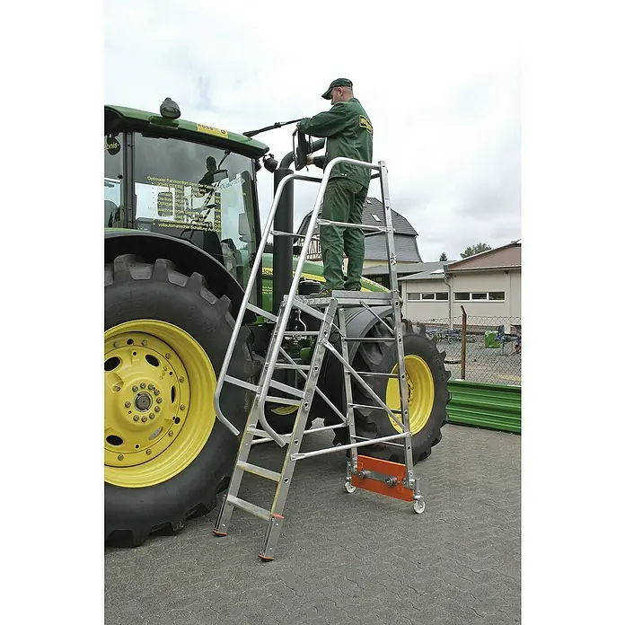 Krause Stabilo Podestleiter Vario kompakt - Arbeitshöhe: 3,65 m, 7 Stk., Aluminium, Ausstattung: Handläufe, B x L: 0,8 x 2,95 m - Mann arbeitet mit einer mobilen Montagestufe an einem Traktor. Die Montagestufe ist aus Aluminium gefertigt und hat Rollen.
