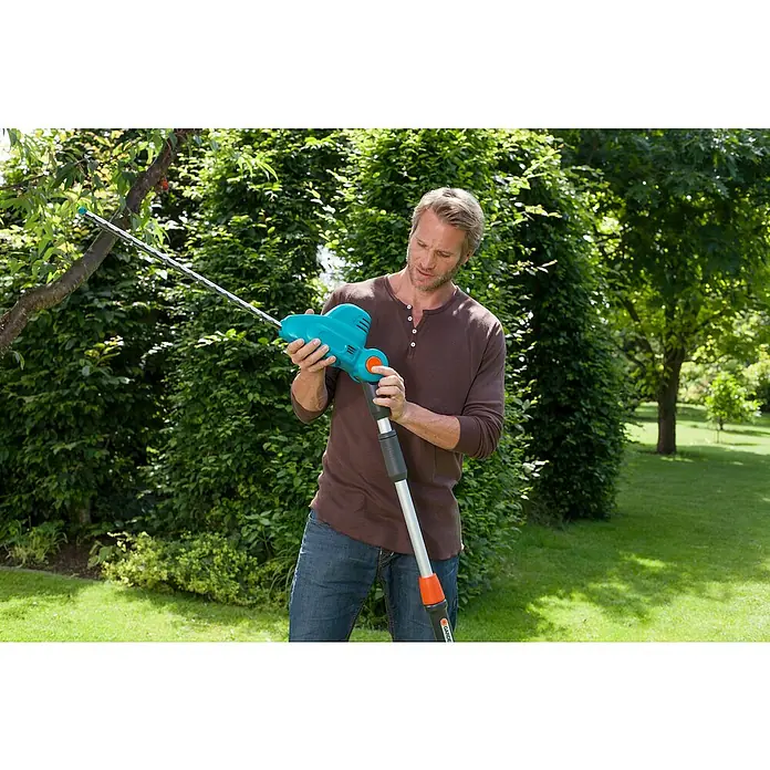 Gardena Teleskop-Heckenschere THS 500/48 - 500 W, Schwertlänge: 48 cm - Mann benutzt eine Gardena Akku-Teleskop-Heckenschere, um Äste in einem Garten zu schneiden.