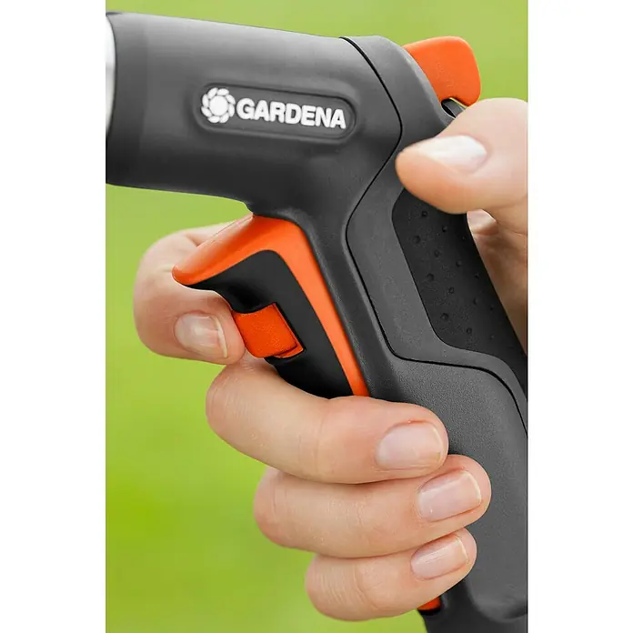 Gardena Premium Brause - 2 -tlg., Kunststoff - Nahaufnahme einer Hand, die eine Gardena Gartenspritze mit orangefarbenen Akzenten betätigt. Das Gerät ist benutzerfreundlich und ergonomisch gestaltet.