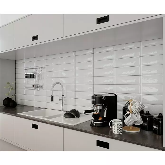 Modern Style Wandfliese Metro Biselado - 9,8 x 29,8 cm, Weiß, Glänzend - Schwarze Espressomaschine brüht Kaffee auf einer modernen Küchenarbeitsplatte mit Tassen und Gläsern.