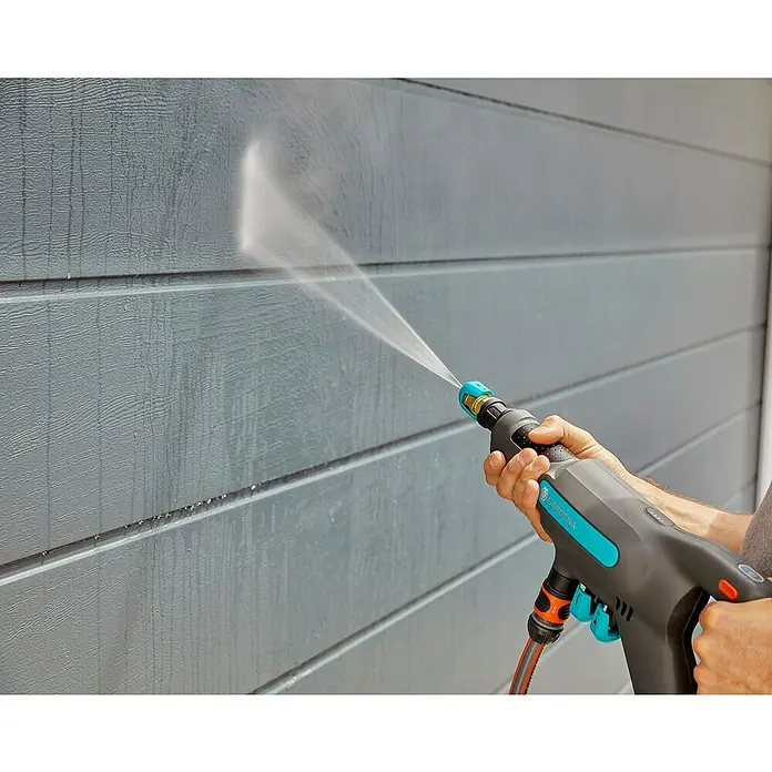 Gardena Power for All 18V Akku-Druckreiniger AquaClean 24/18V SE - 18 V, 1 Akku, 2,5 Ah - Eine GARDENA Akku-Reinigungsgerät im Einsatz gegen eine graue Wand. Ideal für die Gartenarbeit und einfache Reinigung im Außenbereich.
