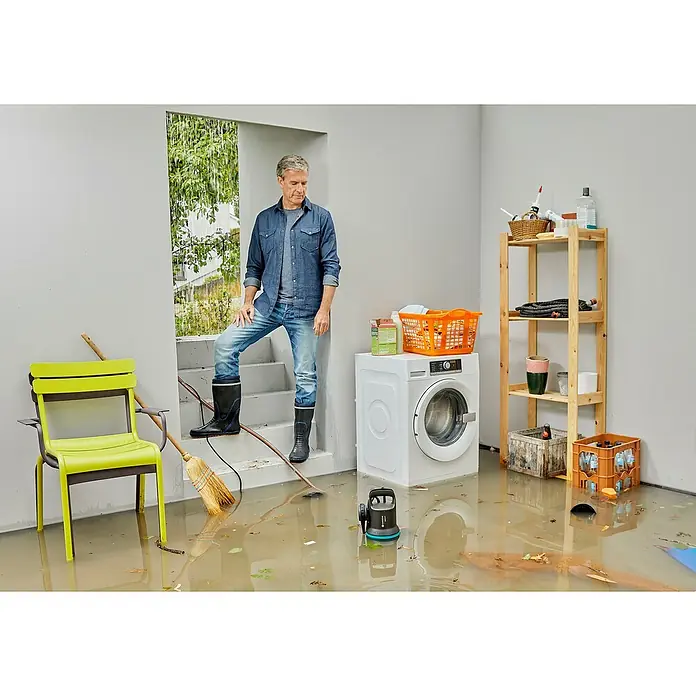 Gardena Schmutzwasserpumpe 9000 - 300 W, Max. Fördermenge: 9.000 l/h, Eintauchtiefe: 7 m - Ein Hausbesitzer steht in einem überfluteten Raum, in dem sich eine Waschmaschine und ein Regal befinden. Der Raum ist durch das Hochwasser beschädigt.