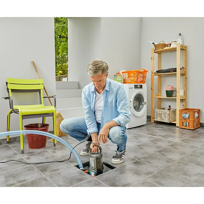 Gardena Bomba de achique sumergible para agua limpia 17000 Aquasensor - 750 W, Capacidad de bombeo máx.: 17.000 l/h - El hombre instala una bomba sumergible de agua sucia Gardena 7000 para eliminar el agua no deseada. Práctica y fiable.