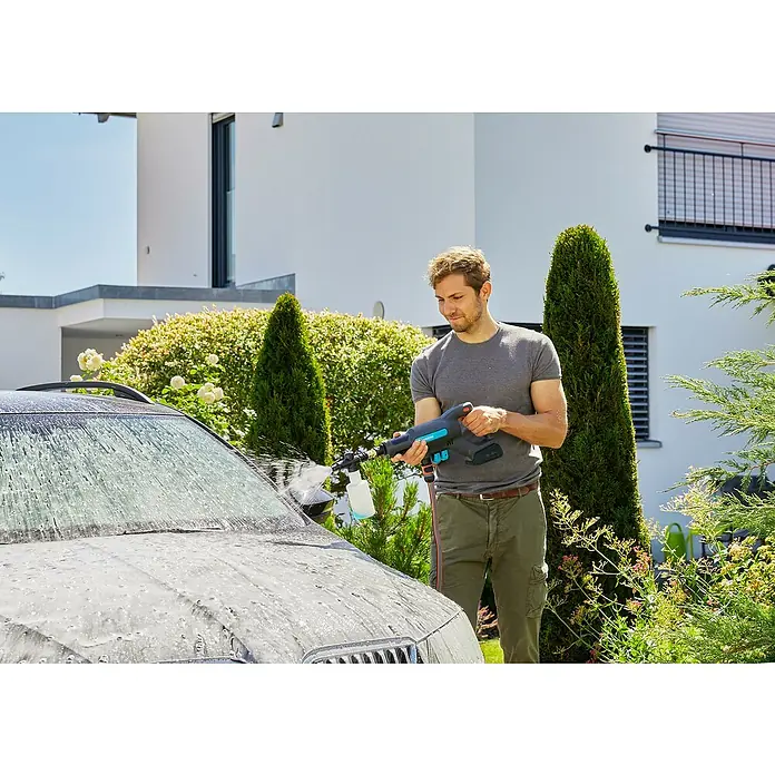 Gardena Power for All 18V Akku-Druckreiniger AquaClean 24/18V SE - 18 V, 1 Akku, 2,5 Ah - Ein Mann wäscht sein Auto mit einem Gardena Akku-Hochdruckreiniger. Das Gerät ist leicht und handlich für den mobilen Einsatz rund ums Haus.