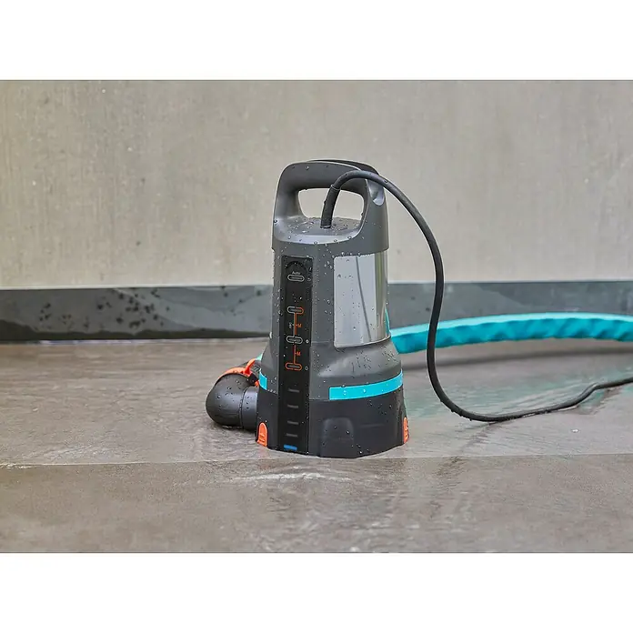 Gardena Klarwasser-Tauchpumpe 11000 Aquasensor - 450 W, Max. Fördermenge: 11.000 l/h - Eine Gardena Schmutzwasser-Tauchpumpe mit Kabel und blauem Schlauch steht auf einem grauen Untergrund. Ideal zum Abpumpen von verschmutztem Wasser.