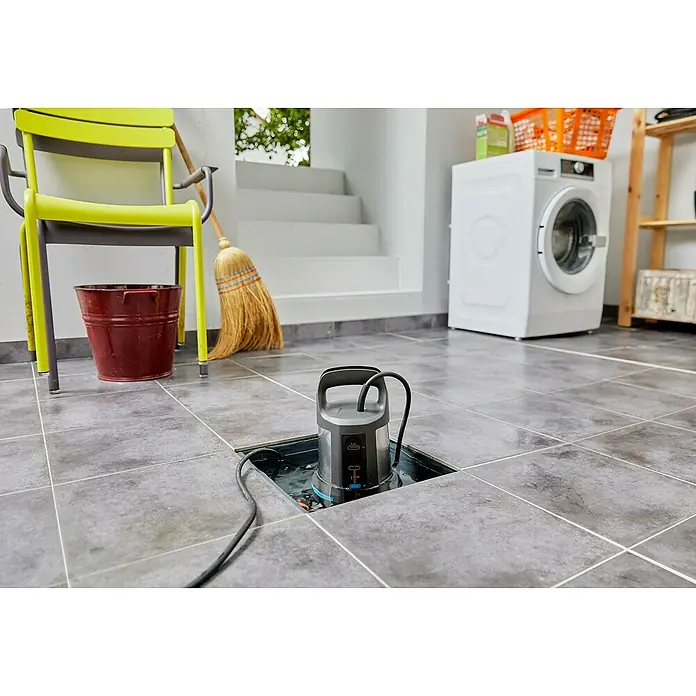 Gardena Klarwasser-Tauchpumpe 11000 Aquasensor - 450 W, Max. Fördermenge: 11.000 l/h - Eine Tauchpumpe steht in einem Schacht mit Wasser, umgeben von Fliesen, neben weiteren Gegenständen in einem Kellerraum.