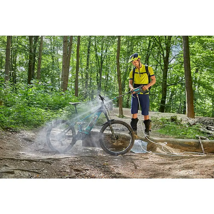 Gardena Power for All 18V Akku-Druckreiniger AquaClean 24/18V PR - 18 V, 1 Akku, 2,5 Ah - Ein Mann in Sportkleidung reinigt mit einem tragbaren GARDENA Akku-Hochdruckreiniger ein schlammiges Mountainbike im Wald.