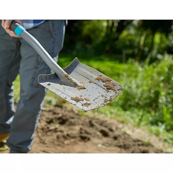 Gardena Ergoline Gärtnerspaten - Mit Tritt, Arbeitsbreite: 19 cm - Graue Schaufel mit blauem Griffakzent, von einer Person gehalten, zeigt Erde auf dem Blatt vom Graben.