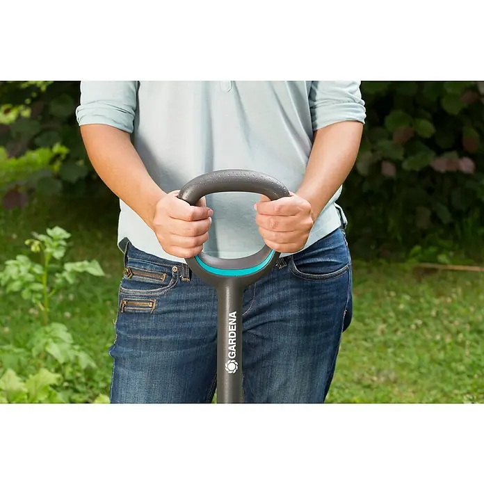 Gardena Ergoline Gärtnerspaten Damen - Mit Tritt, Arbeitsbreite: 16,4 cm - Frau hält eine Gardena Gartenschaufel mit grauem Griff. Ideal zum Umgraben und Auflockern von Erde im Garten.
