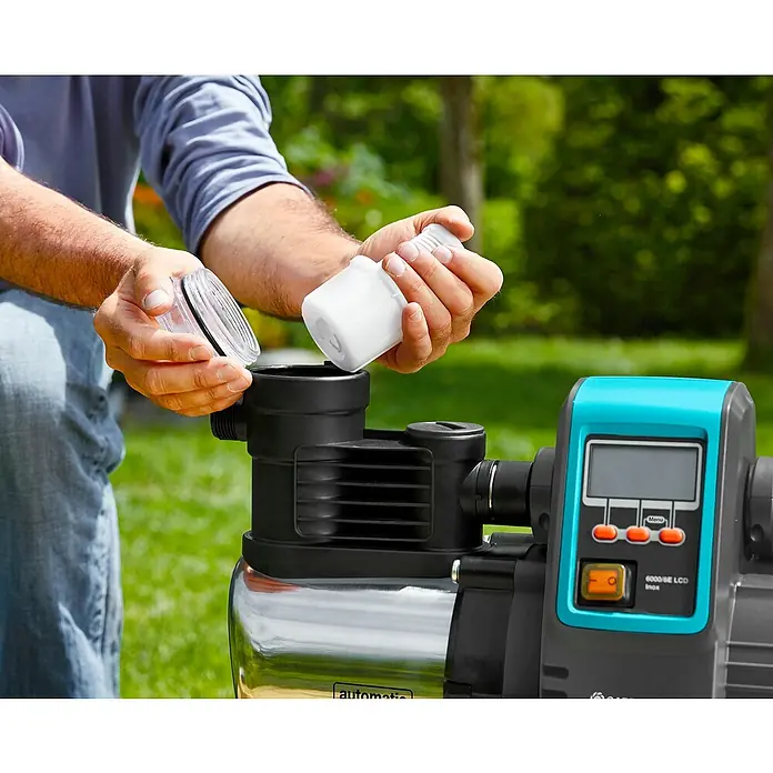 Gardena Bewässerungspumpe Haus- & Gartenautomat 6000/6 LCD inox - 1.300 W, Max. Fördermenge: 6.000 l/h - Die Gardena Hauswasseranlage 6000/6E LCD inox im Einsatz: Ein Mann setzt den Filter ein. Ideal für die Gartenbewässerung!